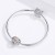 Ażurowy charms Serce Koniczynki prezentowany na bransoletce modułowej. Zawieszka Amélioré ozdobiona białymi cyrkoniami oraz czterolistną koniczynką w kolorze rose gold. Symboliczny charms łączący motyw miłości i szczęścia.